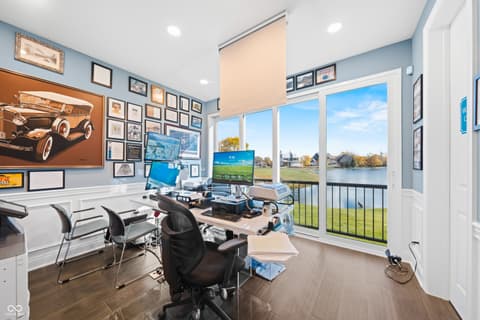 Home office at 4301 Stone Lake Drive, Zionsville, IN — Waterfront office with expansive windows and lake views.