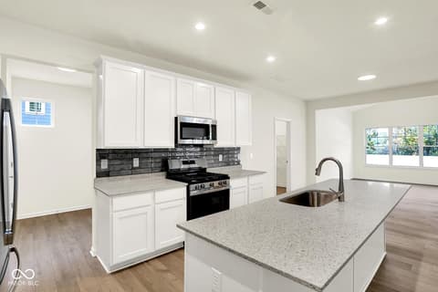 Kitchen at 3746 Thomas Jefferson Court, Westfield, IN — Modern kitchen with white cabinetry and quartz island.