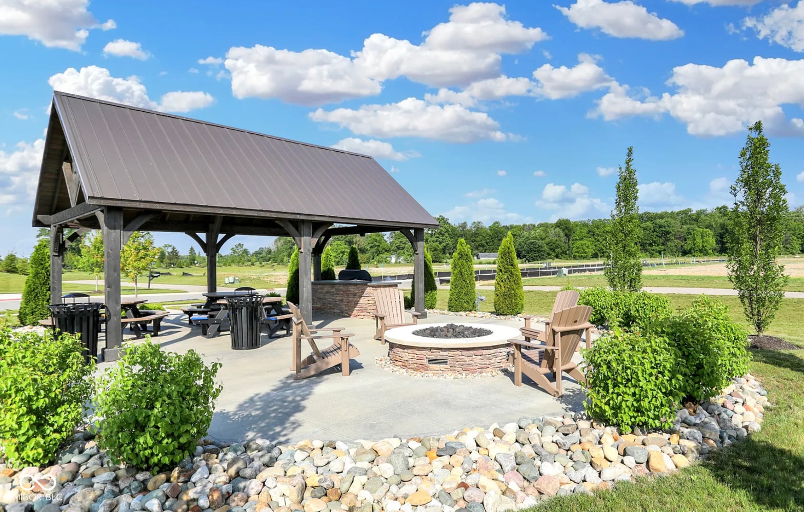 Modern pavilion with fire pit and scenic country views.
