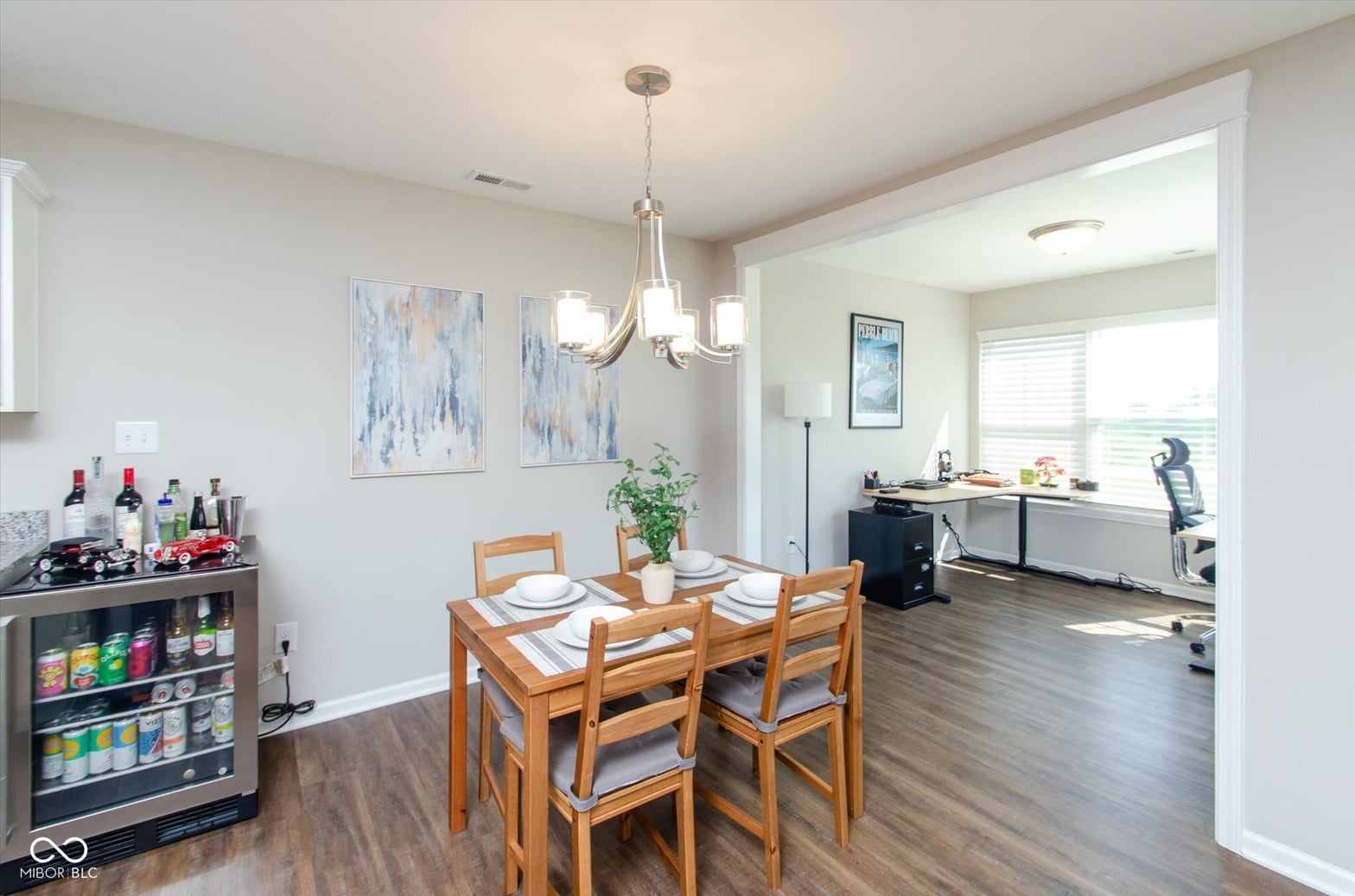 Open dining area with modern lighting and hardwood floors.