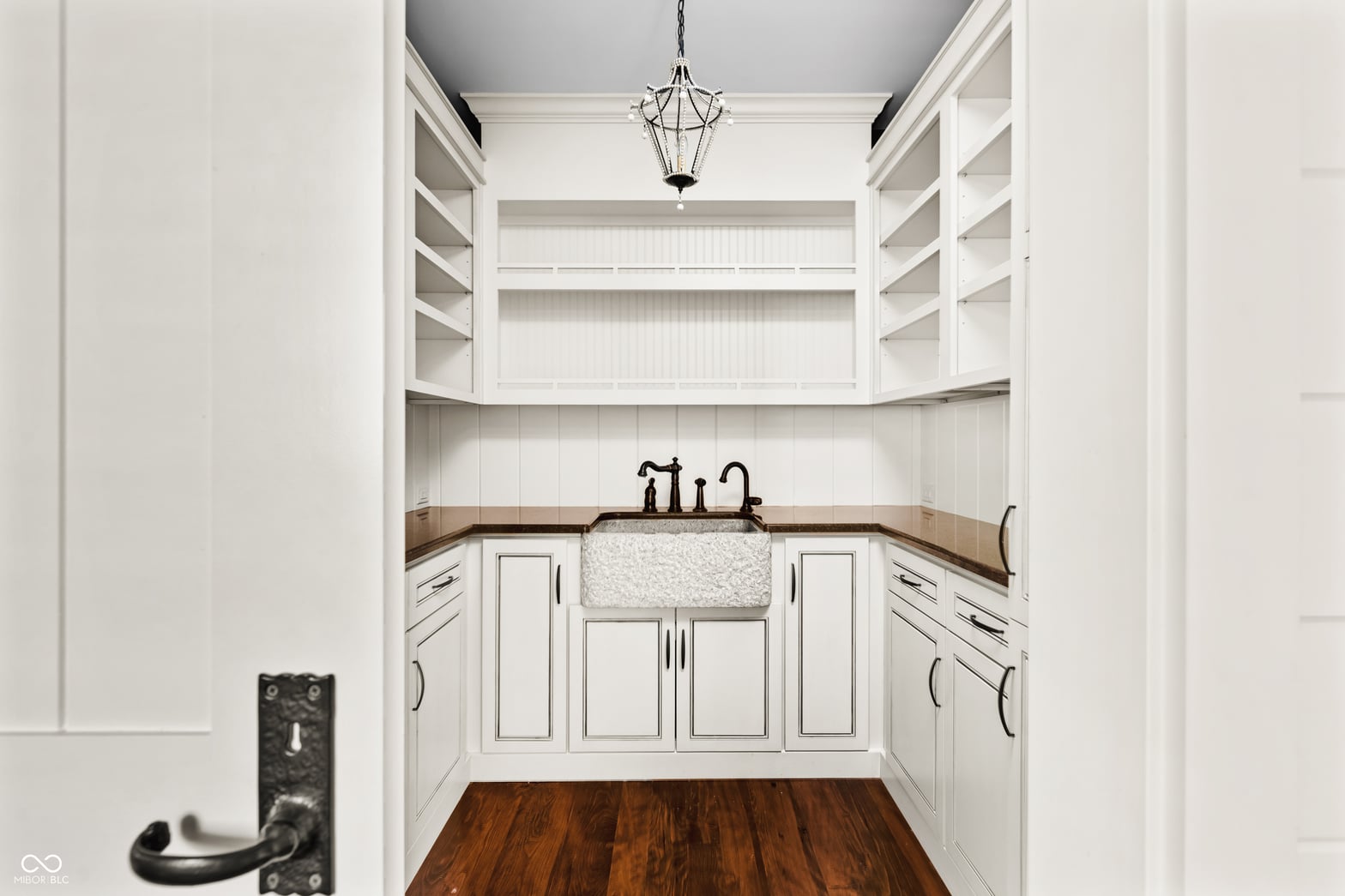 Elegant farmhouse bath with white cabinetry and apron sink.