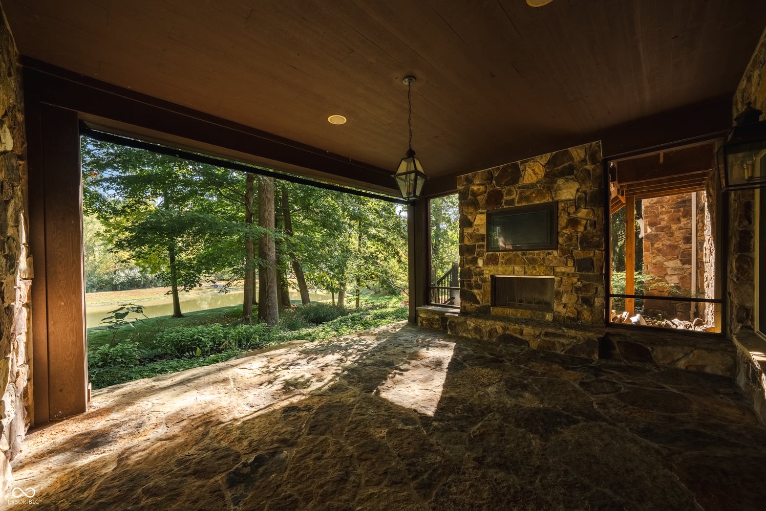 Stunning lakefront covered porch with stone fireplace.