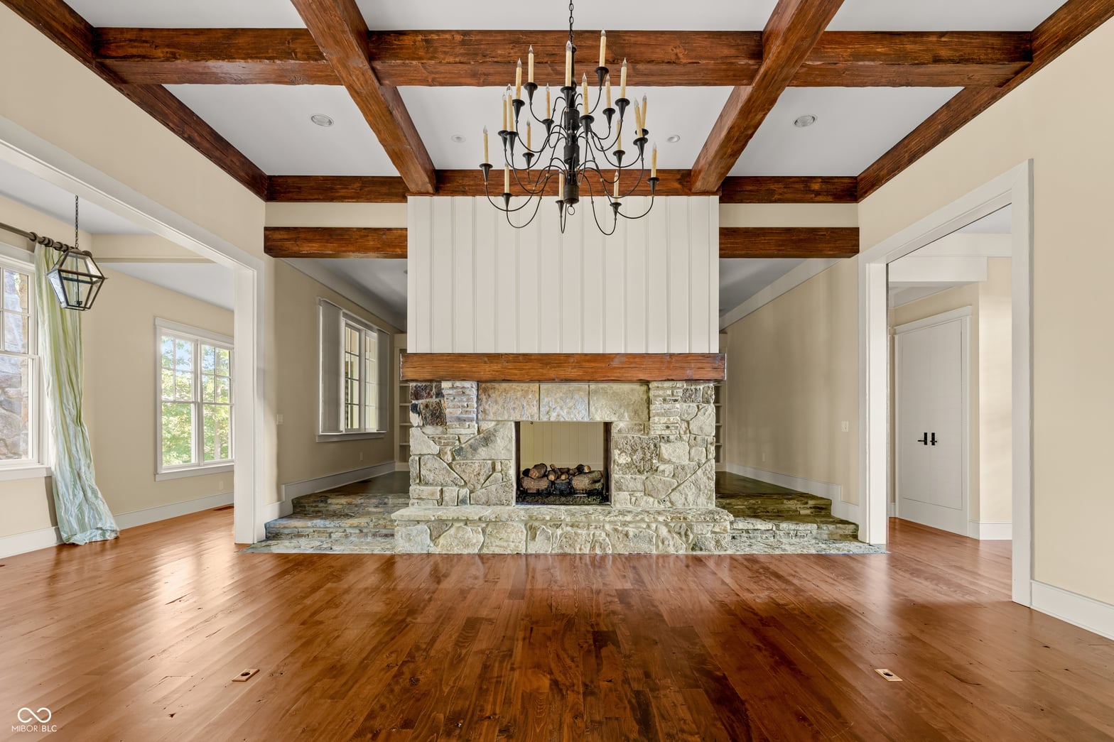 Stunning fireplace anchors spacious family room with exposed beams.