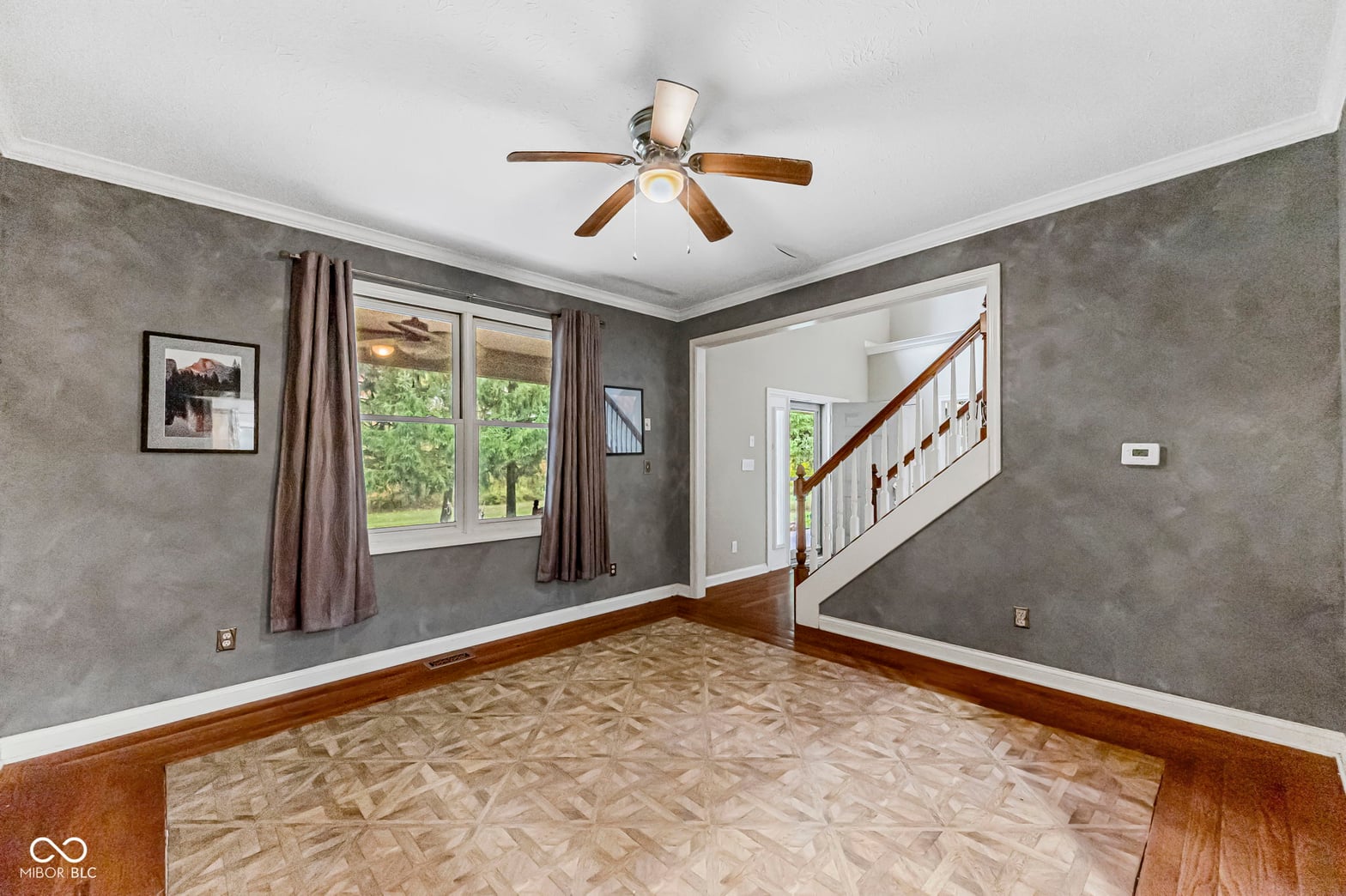 Bright living room with hardwood floors and staircase access.
