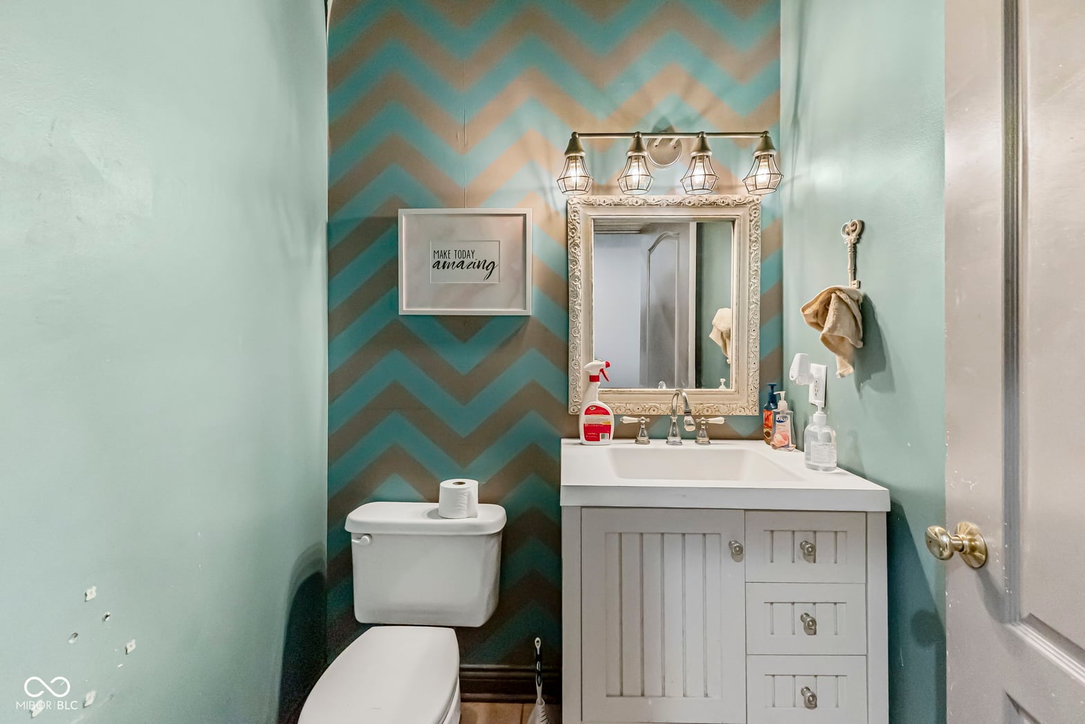 Modern bathroom with bold turquoise chevron accent wall.