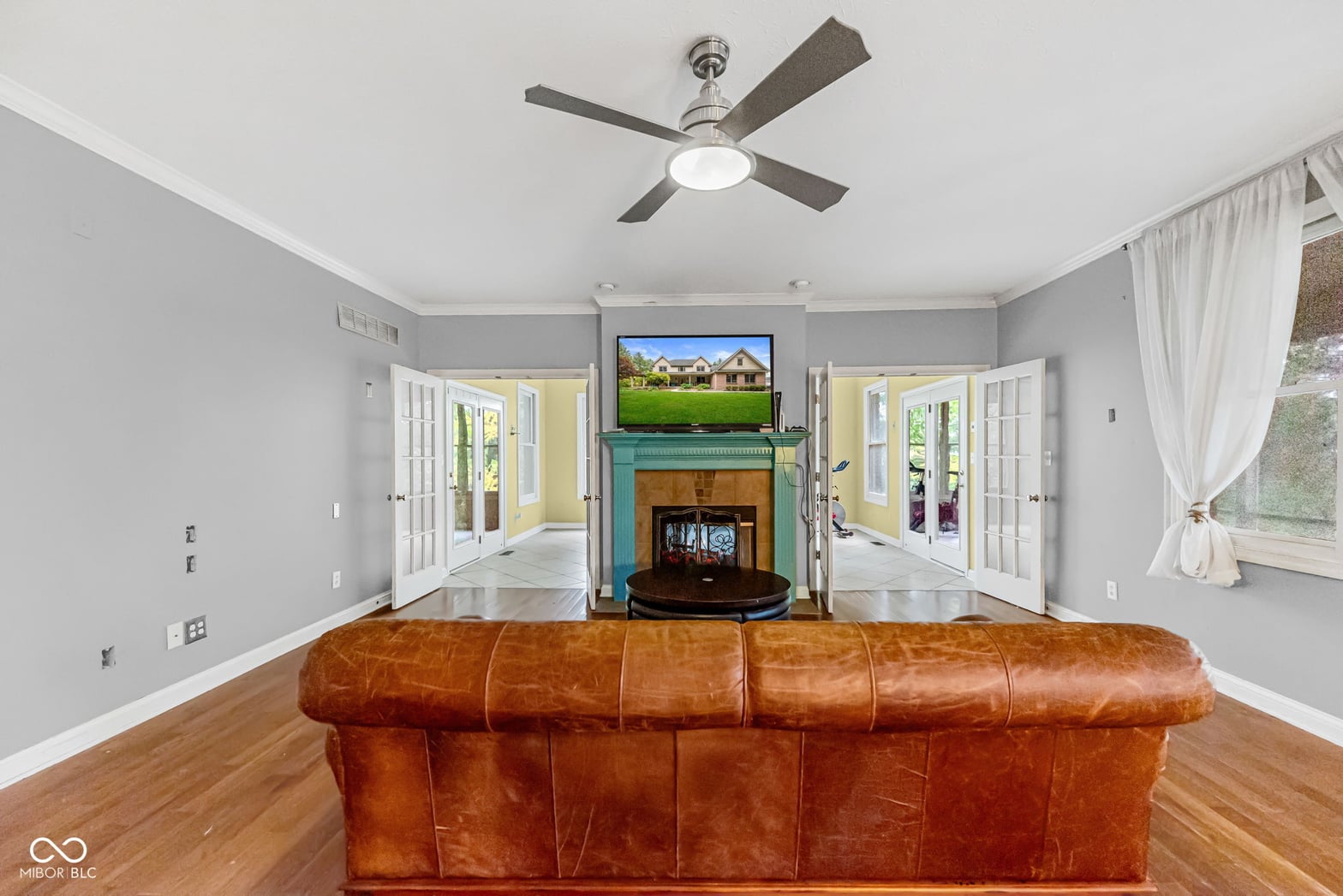 Spacious family room with fireplace and multiple french doors.