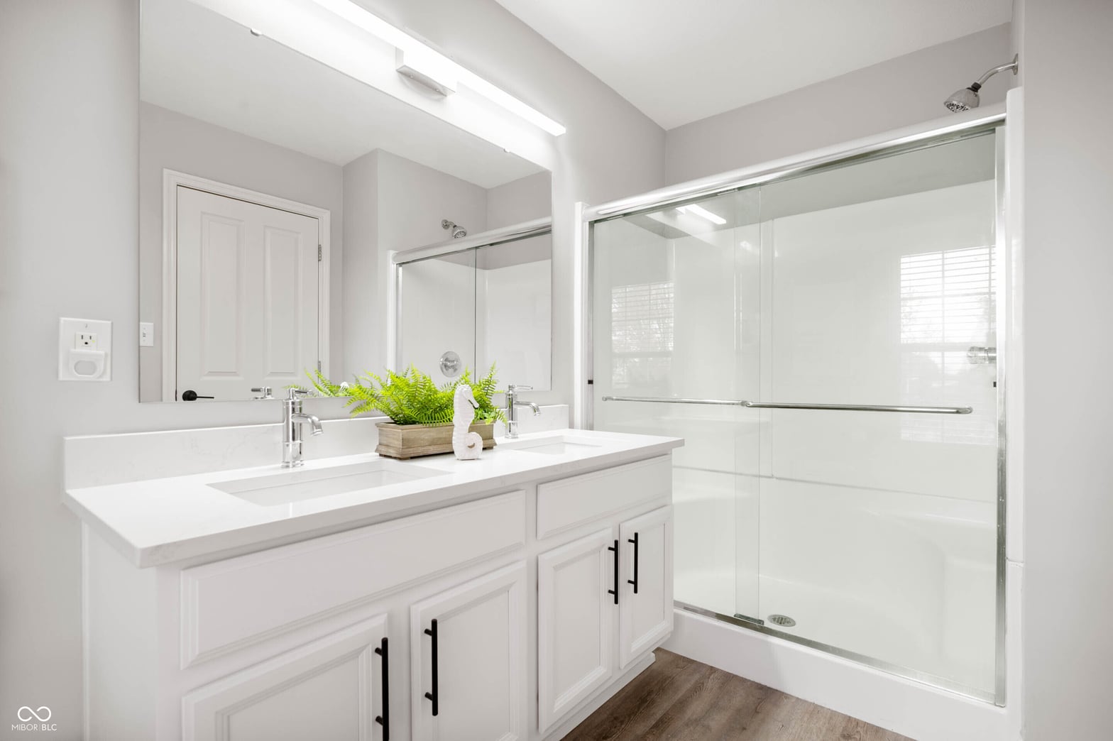 Luxurious primary bath with double vanity and frameless shower.