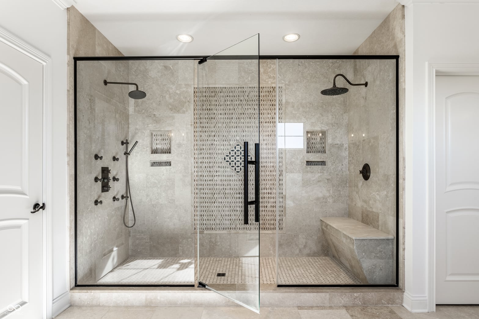Luxurious spa-like primary bath with dual rainfall showerheads.