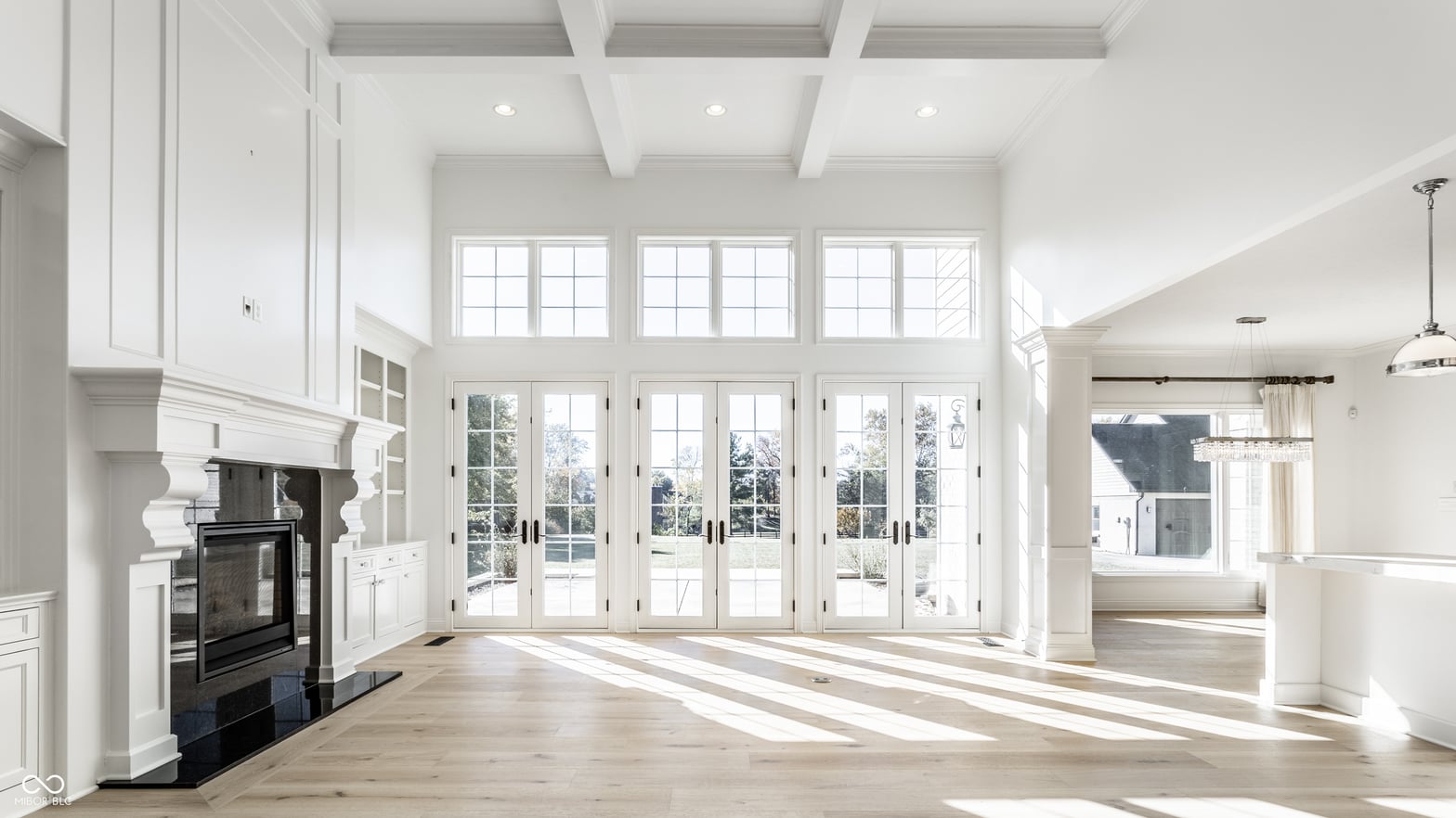 Bright, airy family room with fireplace and wall of glass doors.