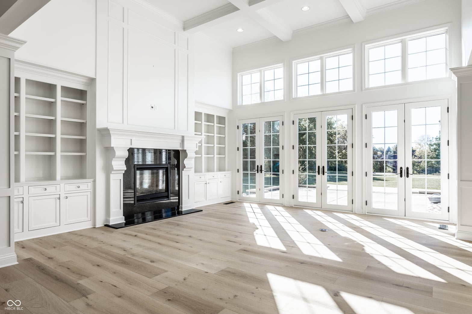 Bright, airy living space with fireplace and French doors.