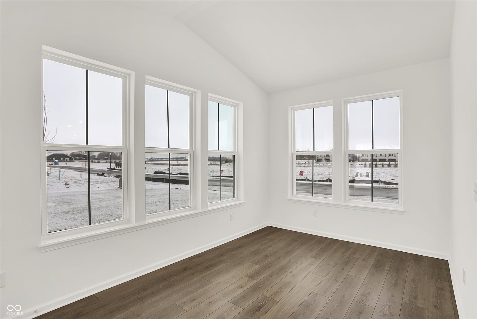 Bright bedroom with expansive windows and water views.