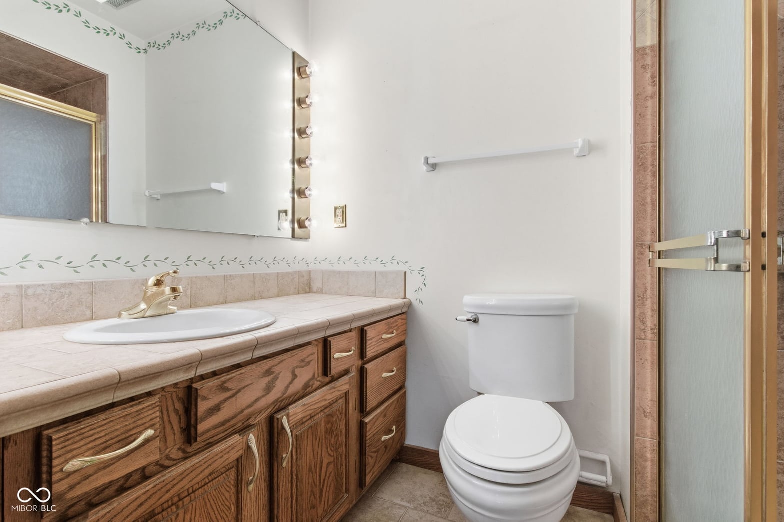 Traditional primary bath with wood vanity and double sink.
