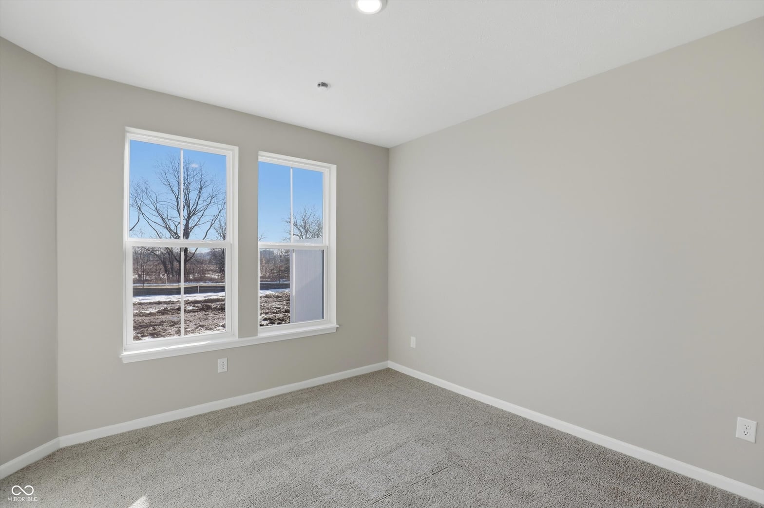Bright bedroom with abundant natural light and large windows.