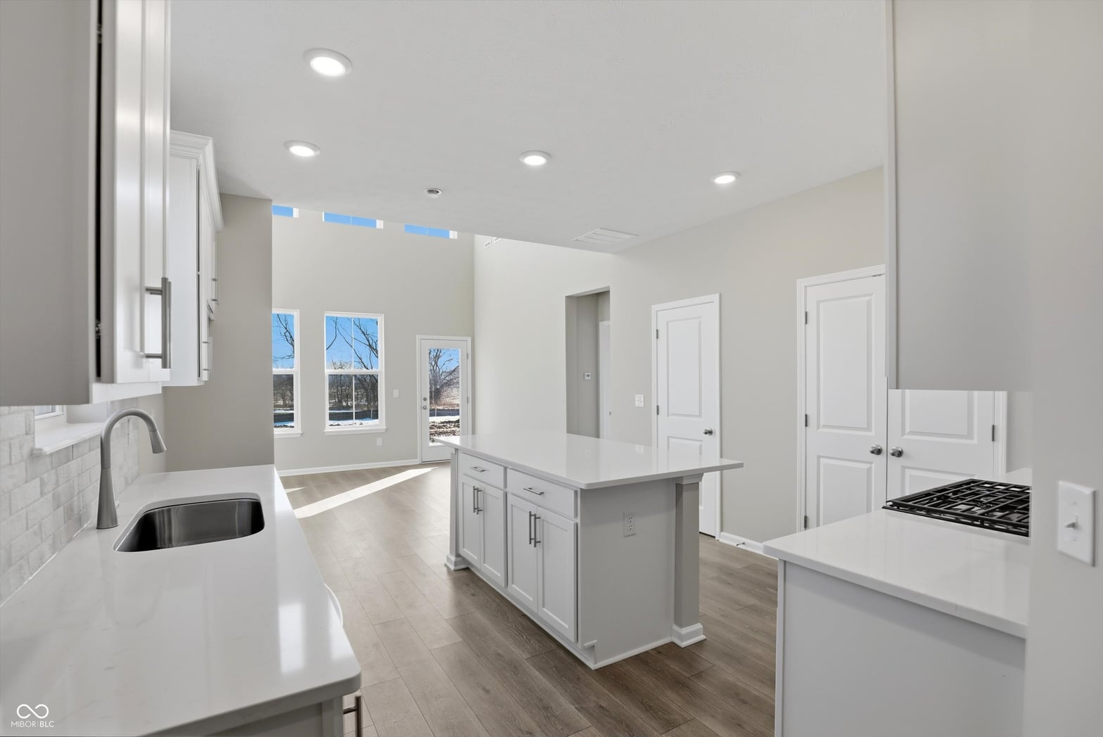 Bright modern kitchen with white cabinetry and quartz counters.