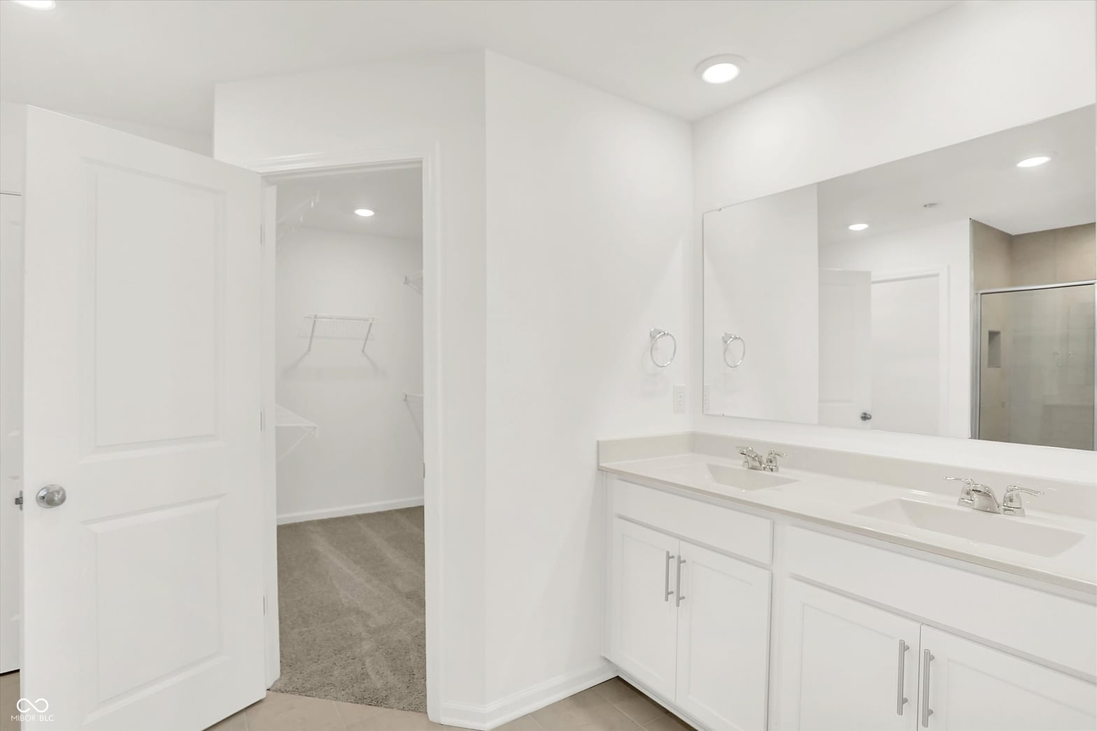 Luxurious primary bath with double vanity and frameless mirror.