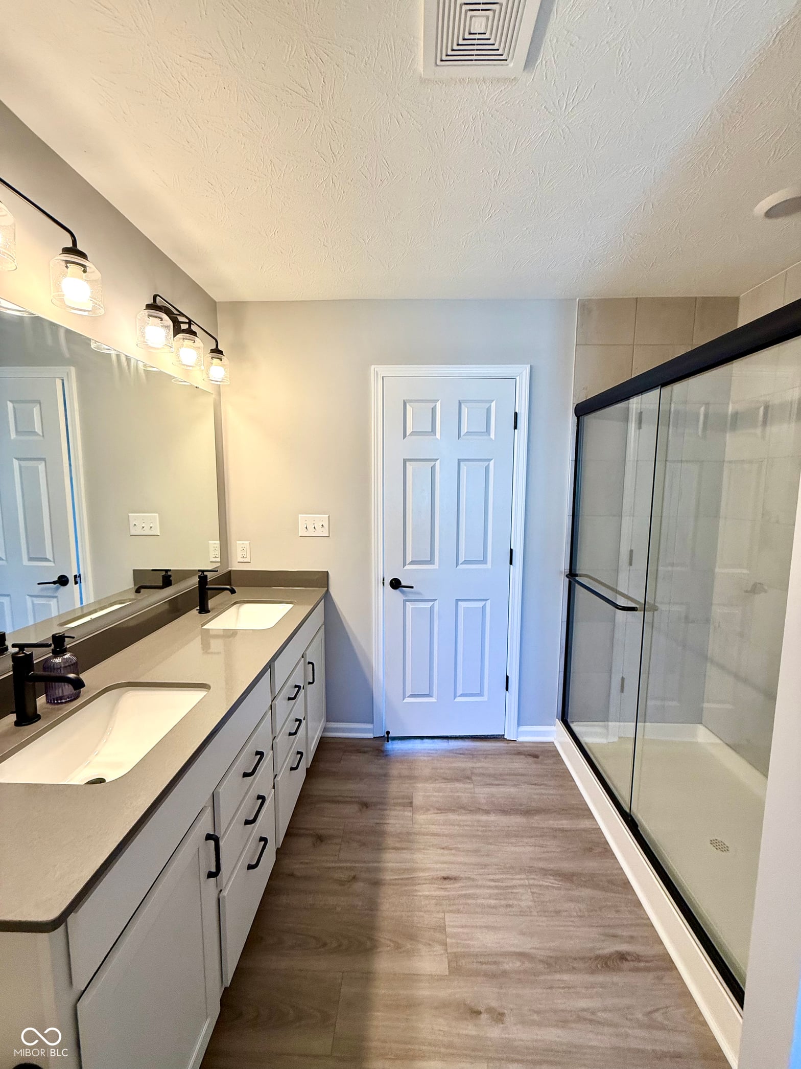 Spacious primary bath with dual vanity and modern shower.