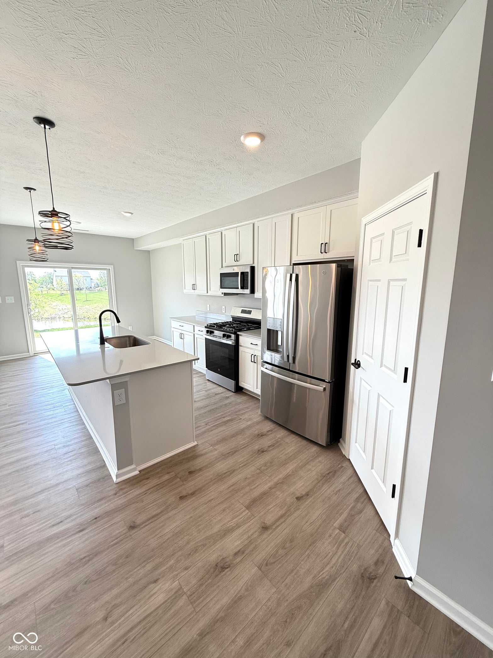 Bright modern kitchen with island and stainless appliances.