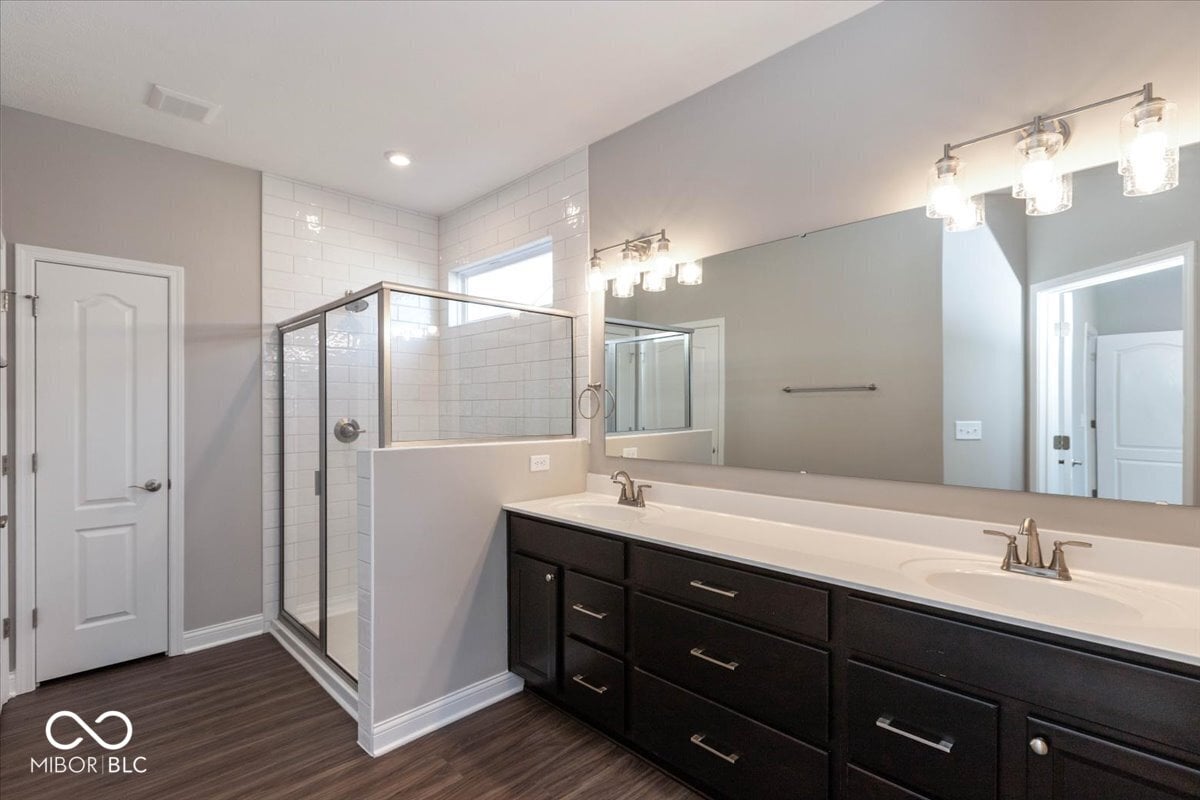Luxurious primary bath with dual vanity and frameless shower.