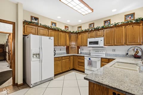 Kitchen at 10791 E State Road 47, Sheridan, IN — Spacious kitchen with granite counters and wood cabinetry.