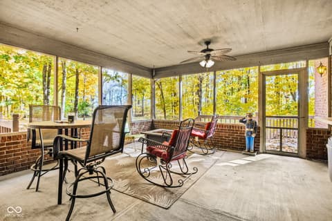 Outdoor living area at 10791 E State Road 47, Sheridan, IN — Spacious screened porch with scenic wooded views.