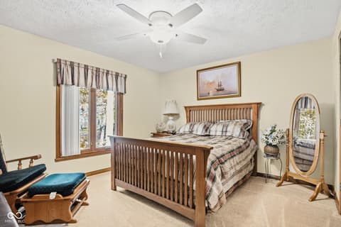 Primary bedroom at 10791 E State Road 47, Sheridan, IN — Bright traditional primary bedroom with wood furnishings.