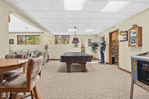 Basement at 10791 E State Road 47, Sheridan, IN — Spacious basement recreation room with pool table and games.