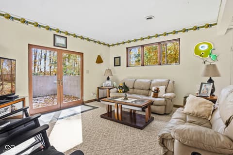 Family room at 10791 E State Road 47, Sheridan, IN — Bright family room with patio access and forest views.