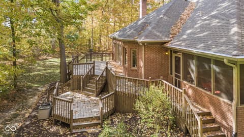 Backyard at 10791 E State Road 47, Sheridan, IN — Multi-level deck with screened porch in wooded setting.
