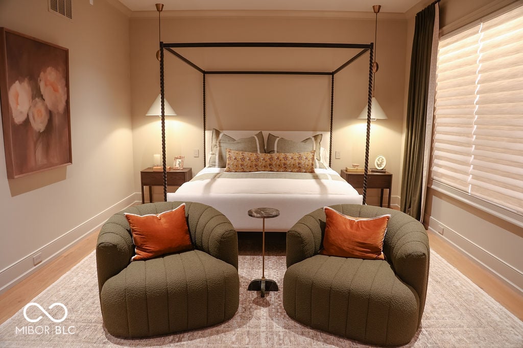 Luxurious primary suite with designer canopy bed and seating.