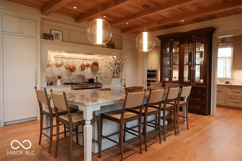 Elegant kitchen with marble, exposed beams, and custom cabinetry.