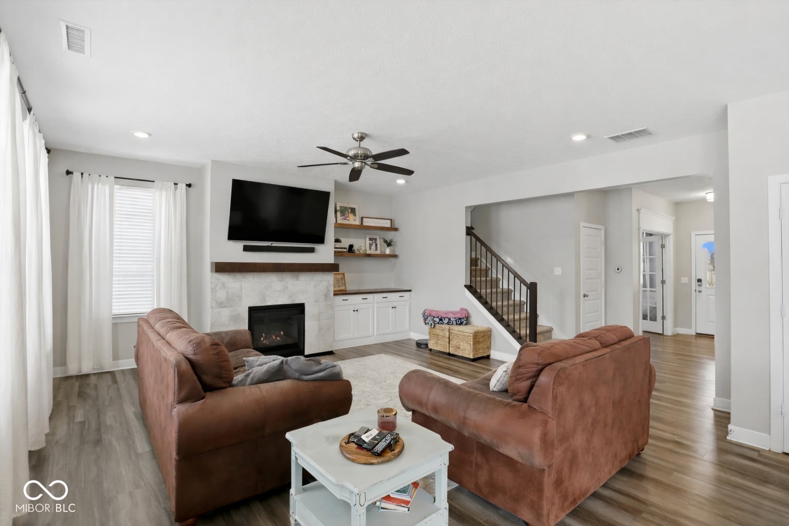 Open-concept living with fireplace and modern entertainment space.