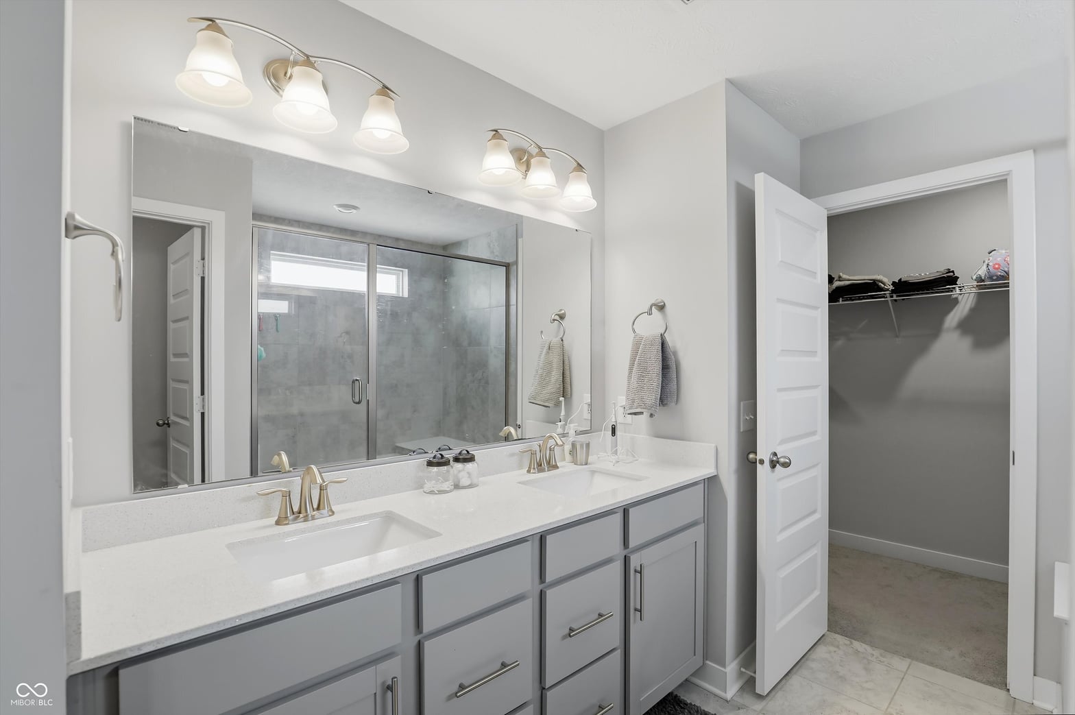 Spacious primary bath with double vanity and frameless shower.