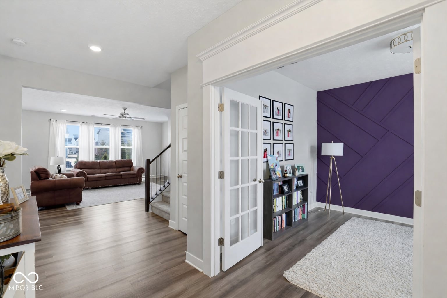 Open concept with bold purple accent wall and built-ins.