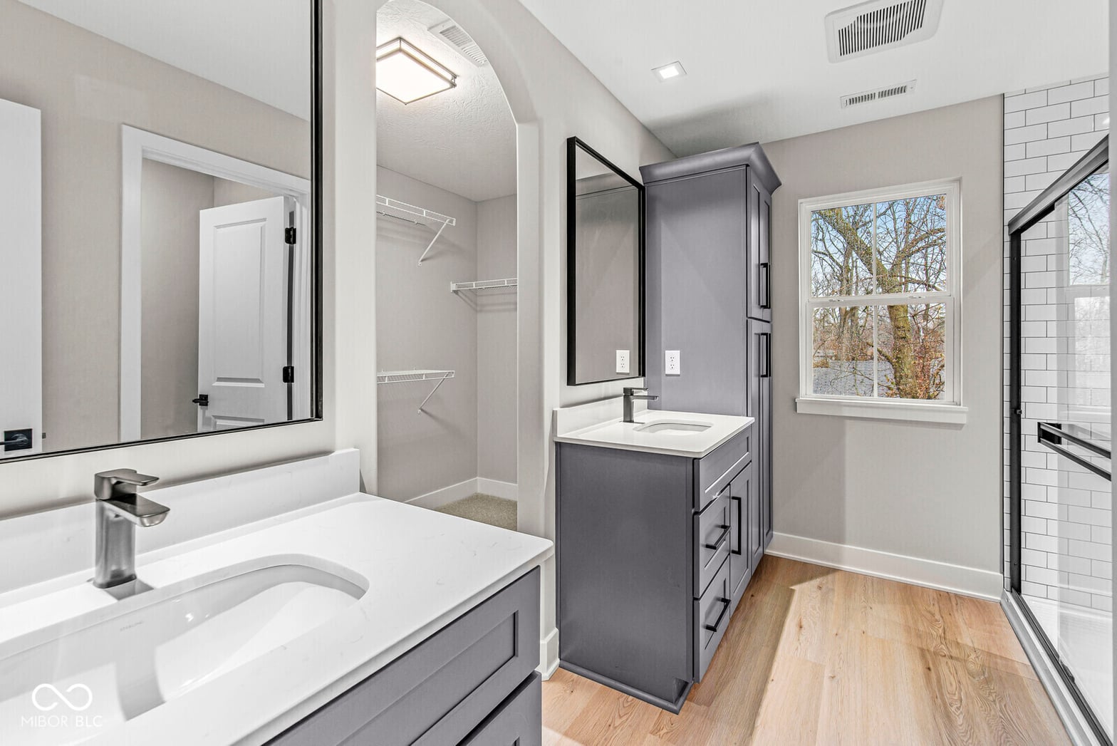 Luxurious primary bath with double vanity and frameless shower.