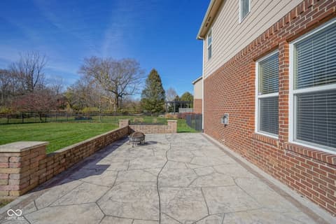Outdoor living area at 14903 Stable Stone Terrace, Fishers, IN — Spacious stamped patio with fire pit and views.