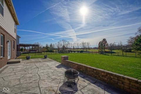 Backyard at 14903 Stable Stone Terrace, Fishers, IN — Expansive fenced backyard with patio and fire pit.