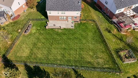 Aerial view at 14903 Stable Stone Terrace, Fishers, IN — Spacious level yard with mature trees and fencing.