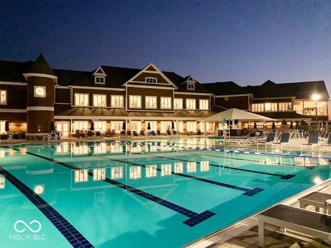 Stunning Olympic pool with luxury clubhouse and evening ambiance.