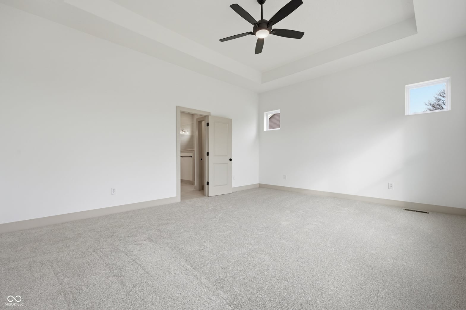 Spacious primary bedroom with ensuite and high ceilings.