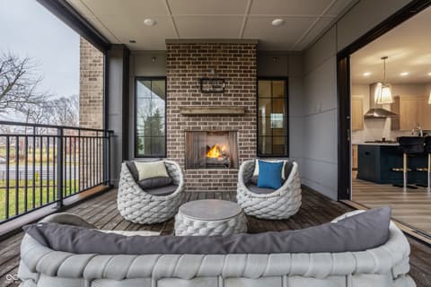 Outdoor living area at 705 Livingstone Drive, Carmel, IN — Luxurious covered patio with fireplace and designer seating.