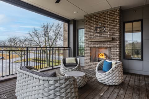 Outdoor living area at 705 Livingstone Drive, Carmel, IN — Modern covered patio with fireplace and water views.