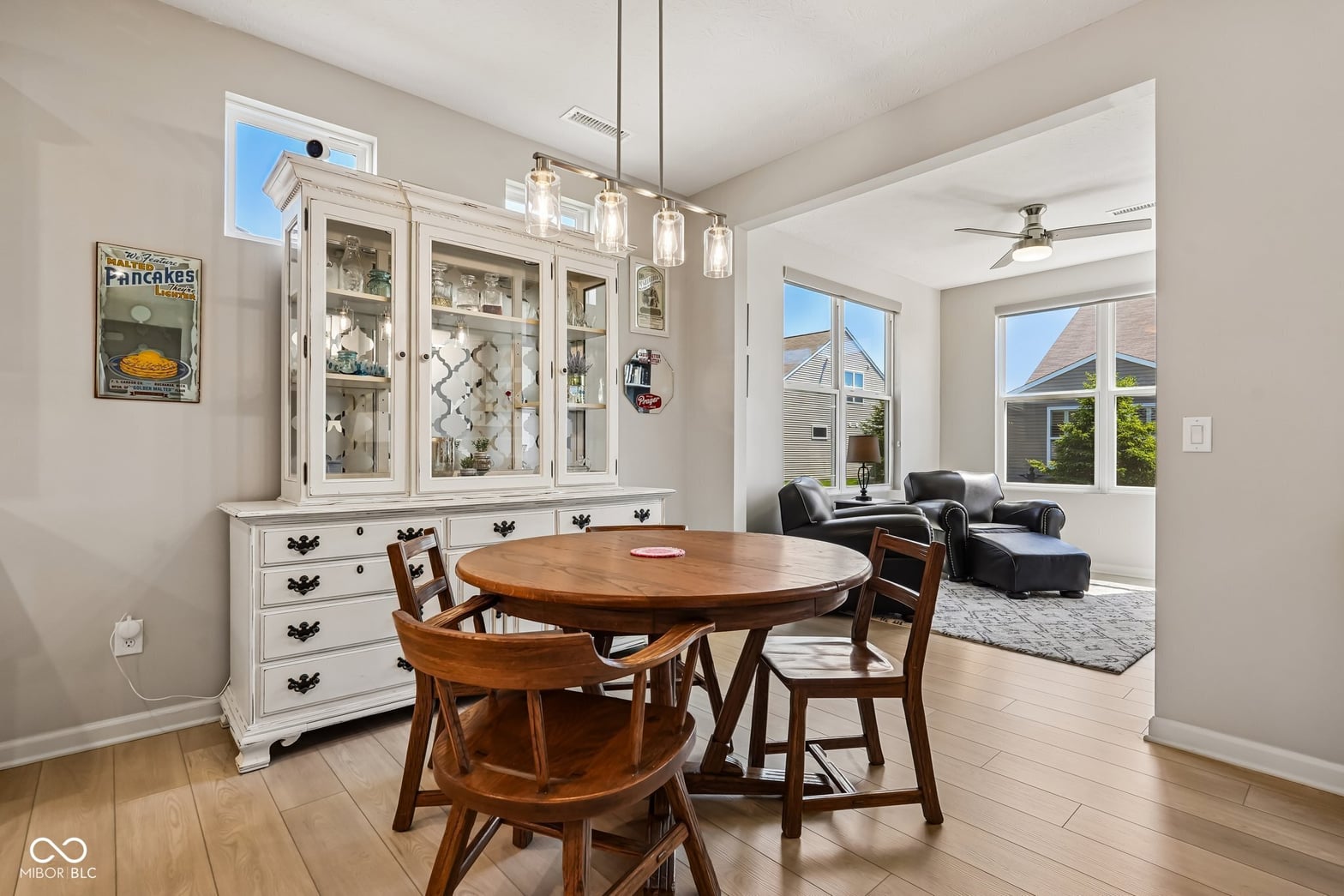 Bright dining room with china cabinet and hardwood floors.