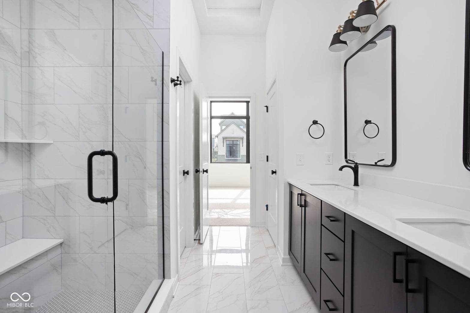 Luxurious spa-like primary bath with marble finishes.