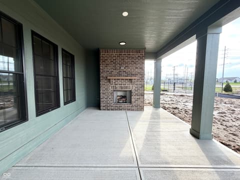 Outdoor living area at 1413 Crosstie Circle, Westfield, IN — Spacious covered patio with built-in fireplace and columns.
