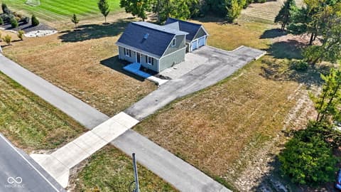 Aerial view at 4991 E Main Street, Carmel, IN — Charming farmhouse on spacious corner lot with mature trees.
