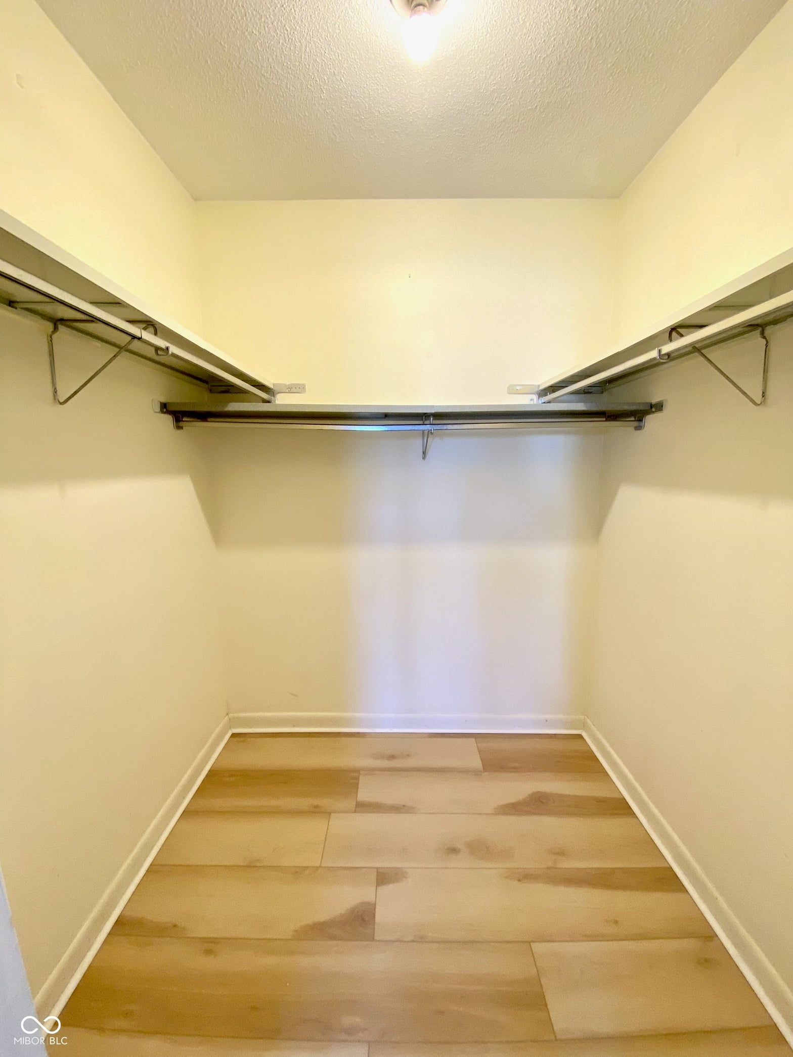 Spacious walk-in closet with dual hanging rods.
