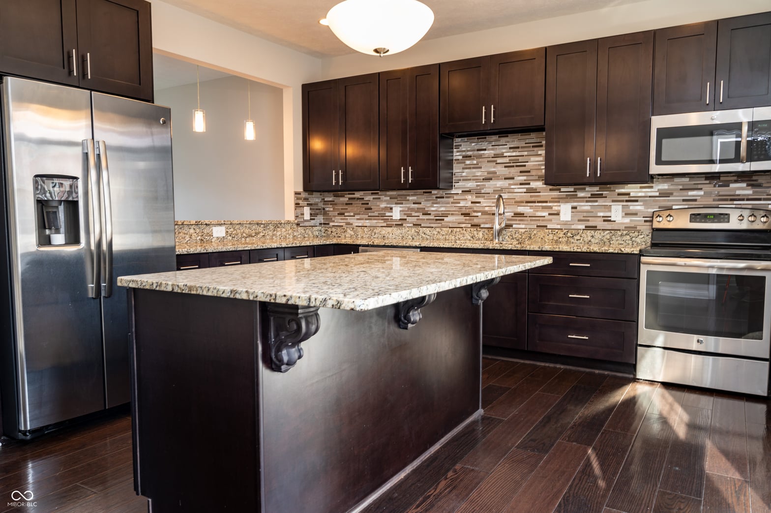 Elegant kitchen with granite island and stainless appliances.