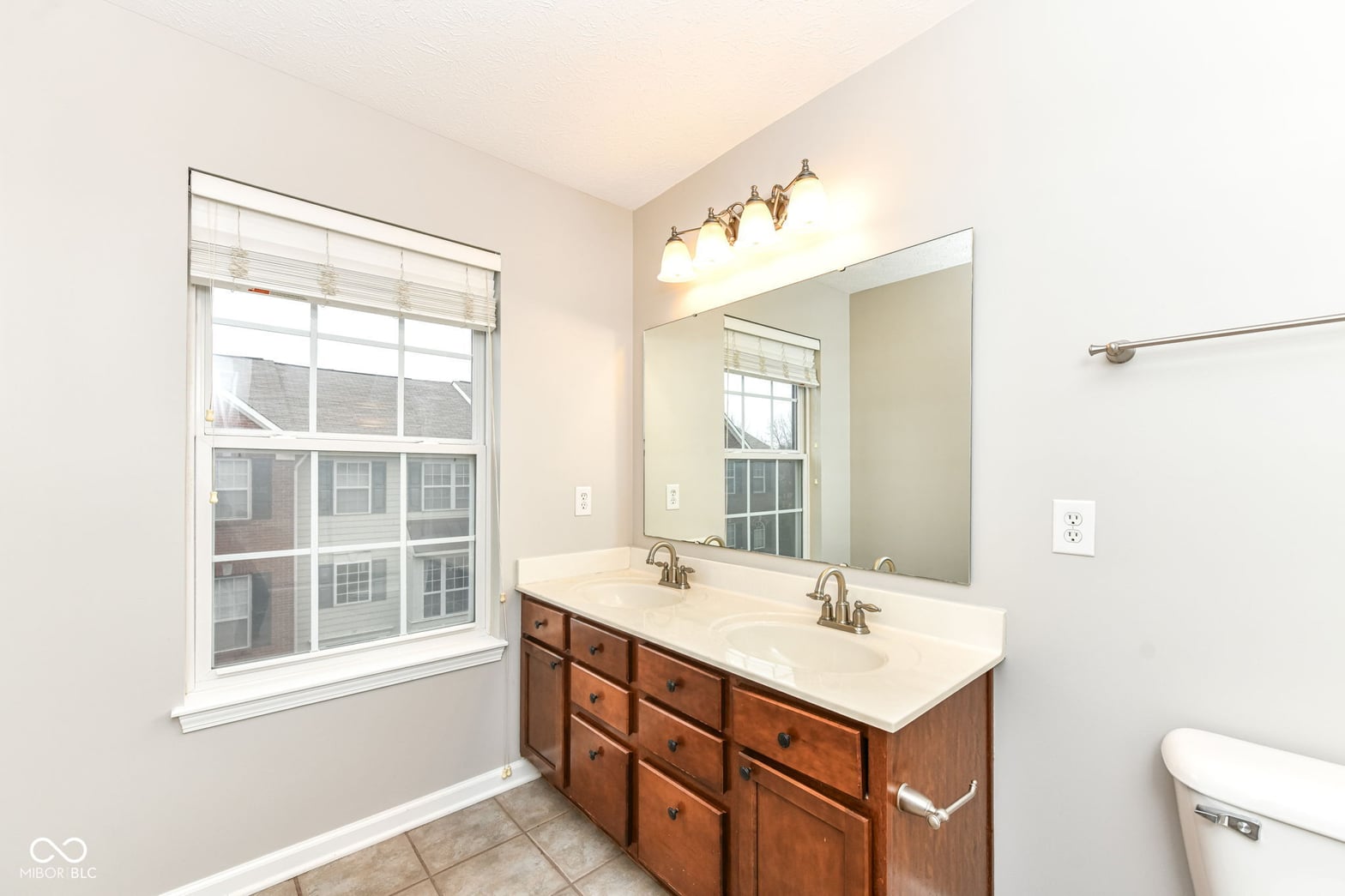 Spacious primary bath with elegant double vanity and natural light.
