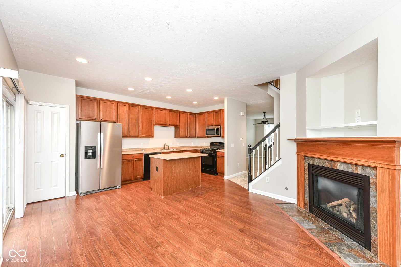 Open concept kitchen with fireplace and updated appliances.