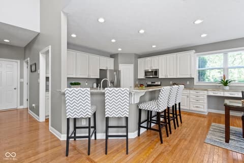 Kitchen at 14825 Latitude Way, Fishers, IN — Modern kitchen with white cabinets and island seating.